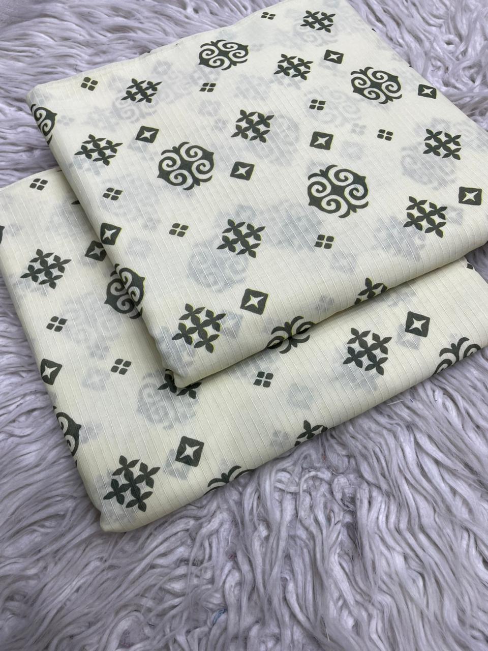 Two pieces of fabric with black geometric patterns on a gray textured surface