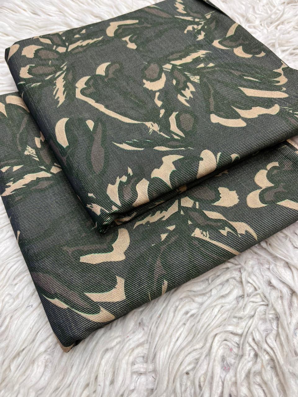 Green fabric with beige floral pattern on a textured white surface