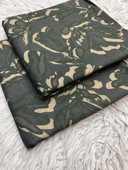 Green fabric with beige floral pattern on a textured white surface