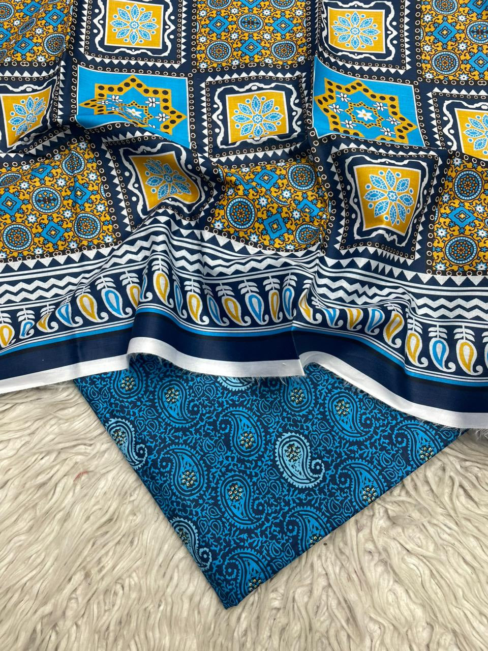 Two pieces of patterned fabric on a textured surface