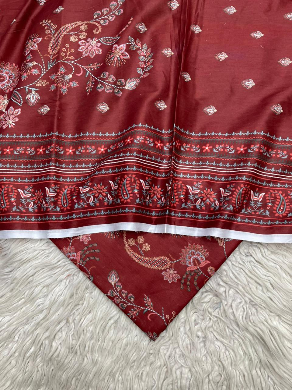 Red fabric with intricate patterns on a textured white surface